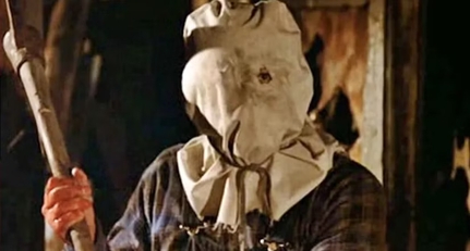 Jason com saco de estopa na cabeça, segurando um forcado